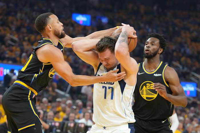 May 18, 2022; San Francisco, California, USA; Dallas Mavericks guard Luka Doncic (77) is defended by Golden State Warriors guard Stephen Curry (30) and forward Andrew Wiggins (22) during the first quarter in game one of the 2022 western conference finals at Chase Center. Mandatory Credit: Kyle Terada-USA TODAY Sports